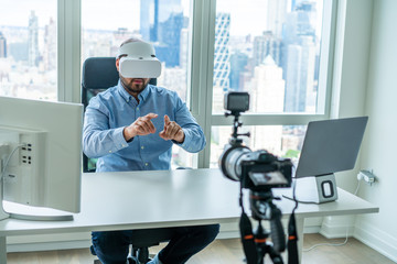 Man working in VR goggles in front of camera