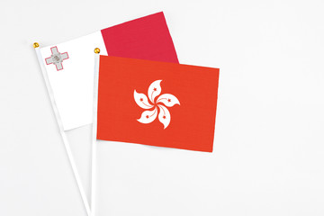 Hong Kong and Malta stick flags on white background. High quality fabric, miniature national flag. Peaceful global concept.White floor for copy space.