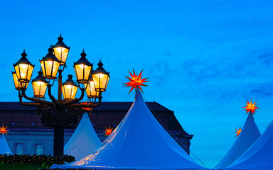 Christmas Market and Street lights at Gendarmenmarkt Winter Berlin, in Germany. Advent Decoration and Stalls with the Crafts Items, on Bazaar. German Xmas holiday fair in European city or town.