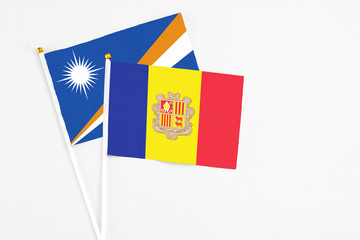 Andorra and Marshall Islands stick flags on white background. High quality fabric, miniature national flag. Peaceful global concept.White floor for copy space.