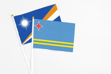 Aruba and Marshall Islands stick flags on white background. High quality fabric, miniature national flag. Peaceful global concept.White floor for copy space.