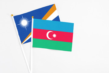 Azerbaijan and Marshall Islands stick flags on white background. High quality fabric, miniature national flag. Peaceful global concept.White floor for copy space.
