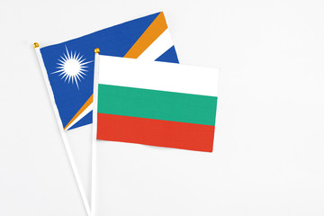 Bulgaria and Marshall Islands stick flags on white background. High quality fabric, miniature national flag. Peaceful global concept.White floor for copy space.