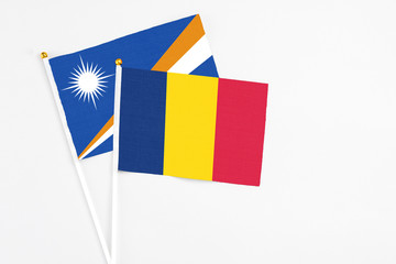 Chad and Marshall Islands stick flags on white background. High quality fabric, miniature national flag. Peaceful global concept.White floor for copy space.