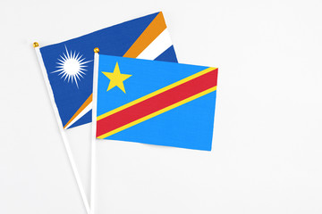 Congo and Marshall Islands stick flags on white background. High quality fabric, miniature national flag. Peaceful global concept.White floor for copy space.