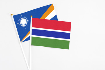Gambia and Marshall Islands stick flags on white background. High quality fabric, miniature national flag. Peaceful global concept.White floor for copy space.