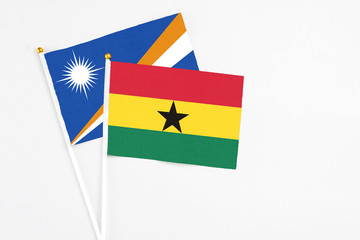 Ghana and Marshall Islands stick flags on white background. High quality fabric, miniature national flag. Peaceful global concept.White floor for copy space.