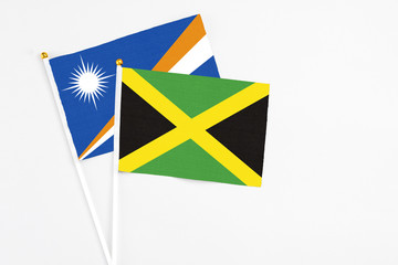 Jamaica and Marshall Islands stick flags on white background. High quality fabric, miniature...