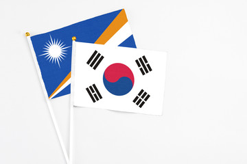 South Korea and Marshall Islands stick flags on white background. High quality fabric, miniature national flag. Peaceful global concept.White floor for copy space.