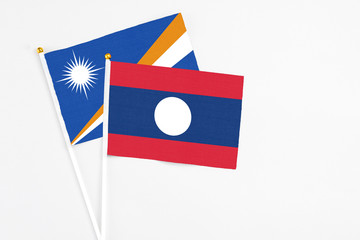 Laos and Marshall Islands stick flags on white background. High quality fabric, miniature national flag. Peaceful global concept.White floor for copy space.