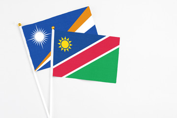 Namibia and Marshall Islands stick flags on white background. High quality fabric, miniature national flag. Peaceful global concept.White floor for copy space.
