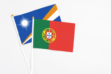 Portugal and Marshall Islands stick flags on white background. High quality fabric, miniature national flag. Peaceful global concept.White floor for copy space.