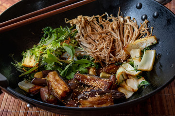 Asian egg plant, mushrooms, cabbage stir fried in wok.