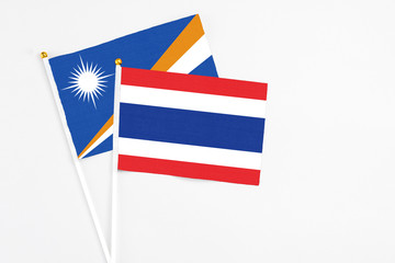Thailand and Marshall Islands stick flags on white background. High quality fabric, miniature national flag. Peaceful global concept.White floor for copy space.