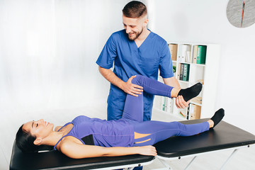 Woman treatment her joint with therapist. Physical therapist helping his patient doing exercise for treatment joint