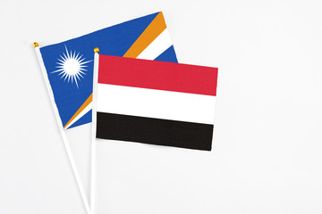 Yemen and Marshall Islands stick flags on white background. High quality fabric, miniature national flag. Peaceful global concept.White floor for copy space.