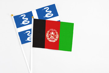 Afghanistan and Martinique stick flags on white background. High quality fabric, miniature national flag. Peaceful global concept.White floor for copy space.