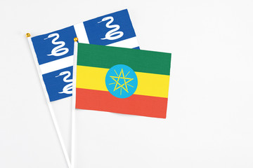 Ethiopia and Martinique stick flags on white background. High quality fabric, miniature national flag. Peaceful global concept.White floor for copy space.