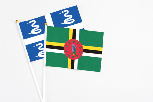 Dominica and Martinique stick flags on white background. High quality fabric, miniature national flag. Peaceful global concept.White floor for copy space.