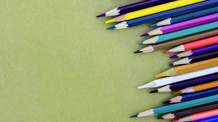 Multicolor sharpened pencils isolated on paper background in a row and messy