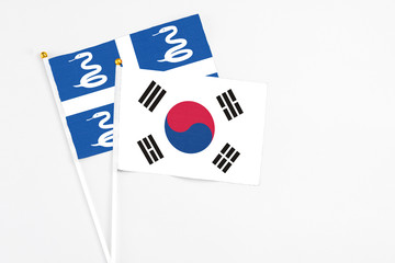 South Korea and Martinique stick flags on white background. High quality fabric, miniature national flag. Peaceful global concept.White floor for copy space.