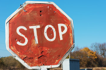 Non-regulated railway crossing in forest area with stop sign.