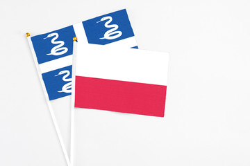 Poland and Martinique stick flags on white background. High quality fabric, miniature national flag. Peaceful global concept.White floor for copy space.