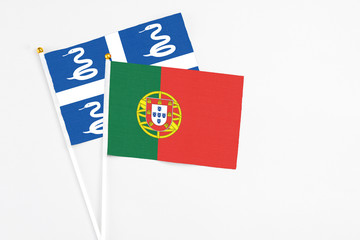 Portugal and Martinique stick flags on white background. High quality fabric, miniature national flag. Peaceful global concept.White floor for copy space.