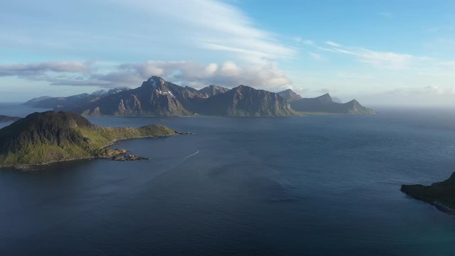 aerial view. flight over the sea,view on the Flakstadoya from Haukland beach and Mannen peak. Camera move backward .Lofoten Islands,Norway