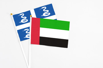 United Arab Emirates and Martinique stick flags on white background. High quality fabric, miniature national flag. Peaceful global concept.White floor for copy space.