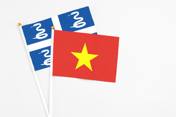 Vietnam and Martinique stick flags on white background. High quality fabric, miniature national flag. Peaceful global concept.White floor for copy space.