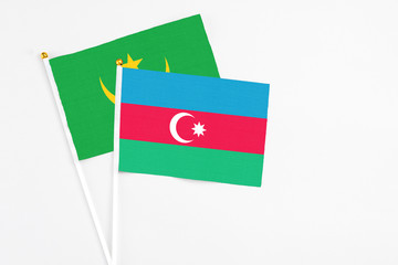 Azerbaijan and Mauritania stick flags on white background. High quality fabric, miniature national flag. Peaceful global concept.White floor for copy space.