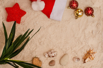 Beach holidays 2019-2020. Holidays at sea on Christmas and New Year. Seashells, palm tree branch and party supplies on the beach sand background. For travel agencies.
