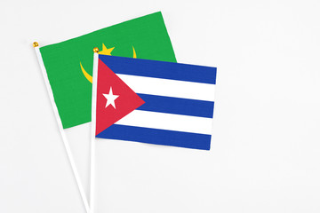 Cuba and Mauritania stick flags on white background. High quality fabric, miniature national flag. Peaceful global concept.White floor for copy space.