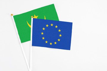 European Union and Mauritania stick flags on white background. High quality fabric, miniature national flag. Peaceful global concept.White floor for copy space.