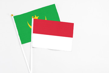 Indonesia and Mauritania stick flags on white background. High quality fabric, miniature national flag. Peaceful global concept.White floor for copy space.