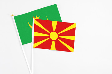 Macedonia and Mauritania stick flags on white background. High quality fabric, miniature national flag. Peaceful global concept.White floor for copy space.