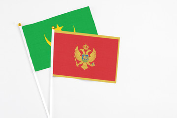 Montenegro and Mauritania stick flags on white background. High quality fabric, miniature national flag. Peaceful global concept.White floor for copy space.