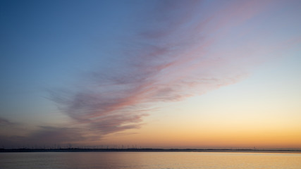Sonnenuntergang an der Nordseeküste über einem Windenergiepark in gold und blau