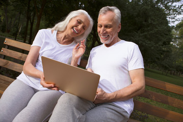 Delighted man and woman with laptop laughing stock photo