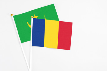 Romania and Mauritania stick flags on white background. High quality fabric, miniature national flag. Peaceful global concept.White floor for copy space.