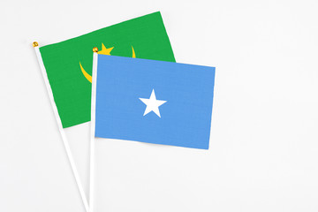 Somalia and Mauritania stick flags on white background. High quality fabric, miniature national flag. Peaceful global concept.White floor for copy space.