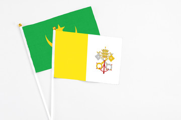 Vatican City and Mauritania stick flags on white background. High quality fabric, miniature national flag. Peaceful global concept.White floor for copy space.