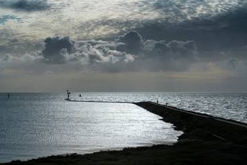 Imposing cloud formations above the pier of West Terschelling .