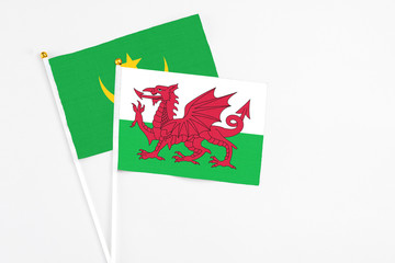 Wales and Mauritania stick flags on white background. High quality fabric, miniature national flag. Peaceful global concept.White floor for copy space.