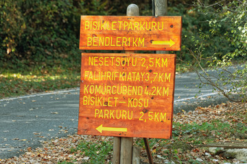 Placard made of wood showing directional and distance information about bicycle and running tracks of Belgrad Forest in Istanbul.
