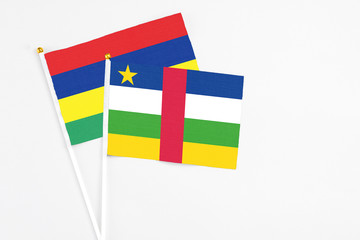 Central African Republic and Mauritius stick flags on white background. High quality fabric, miniature national flag. Peaceful global concept.White floor for copy space.