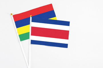 Costa Rica and Mauritius stick flags on white background. High quality fabric, miniature national flag. Peaceful global concept.White floor for copy space.