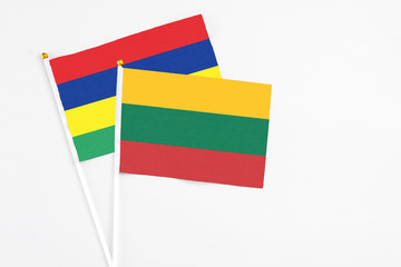 Lithuania and Mauritius stick flags on white background. High quality fabric, miniature national flag. Peaceful global concept.White floor for copy space.