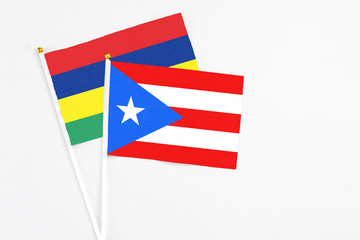 Puerto Rico and Mauritius stick flags on white background. High quality fabric, miniature national flag. Peaceful global concept.White floor for copy space.